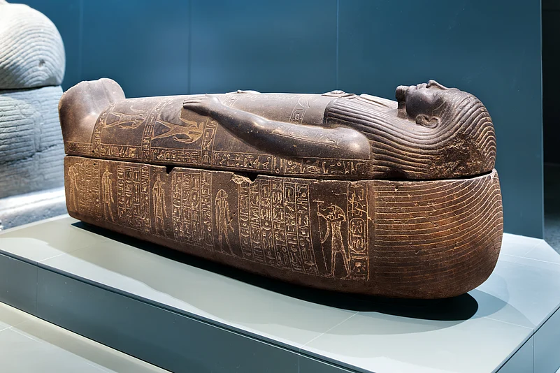 Ancient Egyptian stone sarcophagus with inscribed hieroglyphs, displayed in the Grand Egyptian Museum