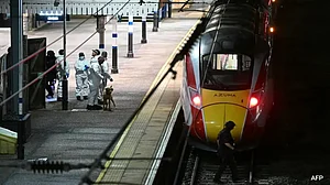 X : Emergency services at Huntingdon after armed police stopped a train following multiple stabbings in Cambridgeshire