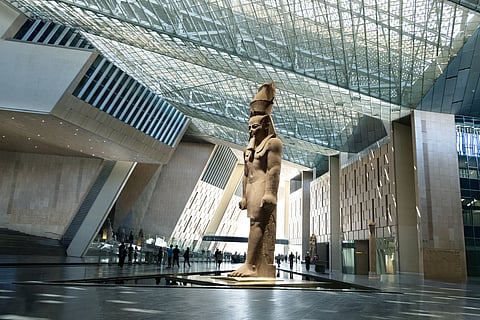Massive ancient Egyptian Ramses II﻿ statue, standing 11 meters tall under the glass skylight of the Grand Egyptian Museum