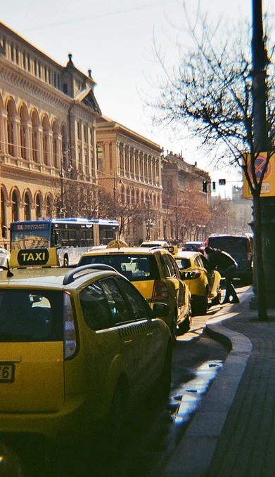 Unsplash : Taxis stand in a queue by the curb