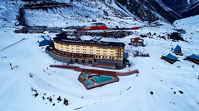 Shutterstock : Hotel Portillo’s bright-yellow façade overlooks the mirror-blue Laguna del Inca, surrounded by towering Andean peaks during Chile’s winter season