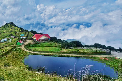 A serene hilltop village in Tonglu, Darjeeling, under a clear blue sky