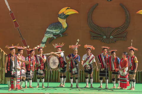 A Naga folk troupe plays music and performs a traditional dance on stage at the Hornbill Festival