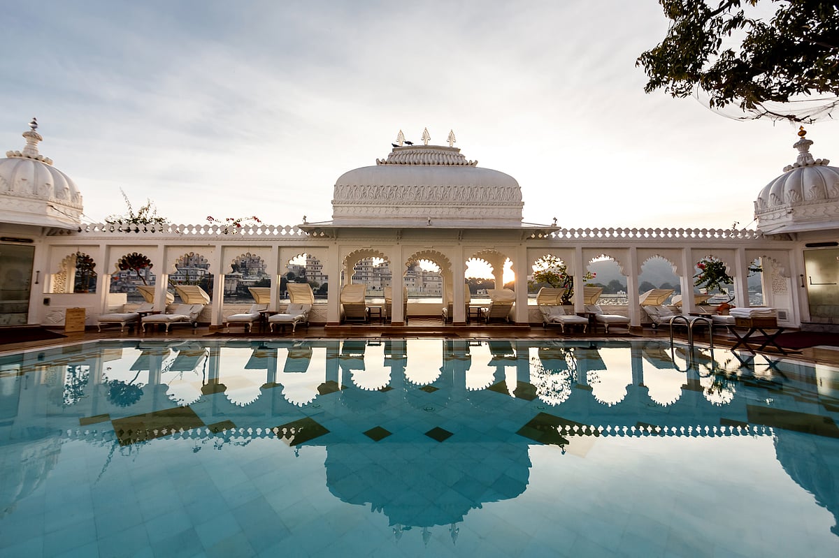 The Taj Lake Palace’s shimmering pool reflects marble arches and twilight hues
