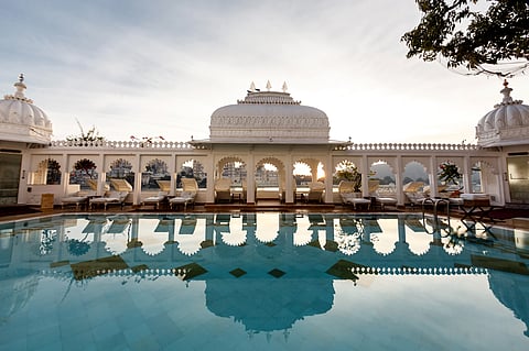The Taj Lake Palace’s shimmering pool reflects marble arches and twilight hues