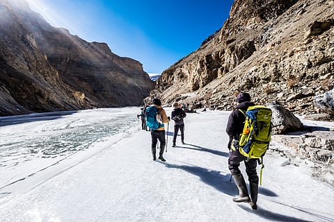 Trekkers walk across the frozen Zanskar River during Ladakh’s deep winter