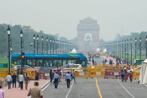 An electric bus passes India Gate in Delhi