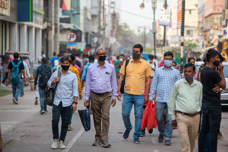 People walk through Karol Bagh’s hazy streets in mask