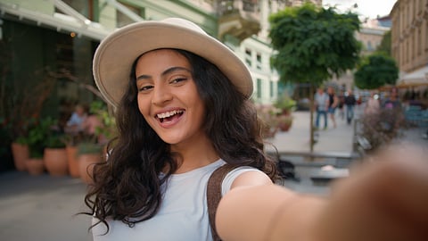 Playful traveller taking a selfie outside a city café