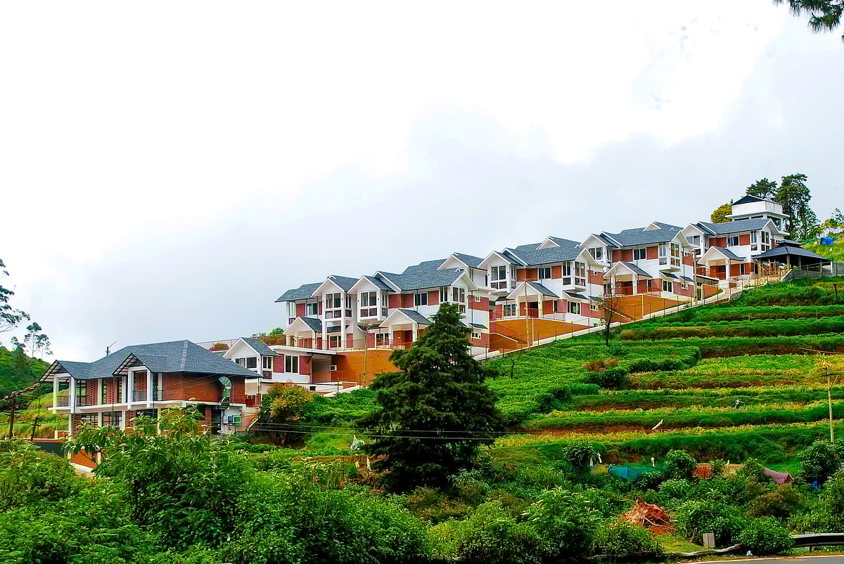Lush mountains and drifting clouds frame the serene village landscape of Ooty in the Nilgiris