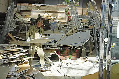AP : A worker clears debris inside a damaged building after Japan’s earthquake