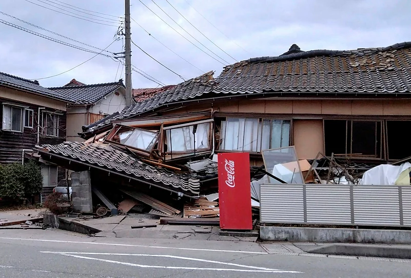A collapsed building in northern Japan after the powerful earthquake, with debris scattered across the street