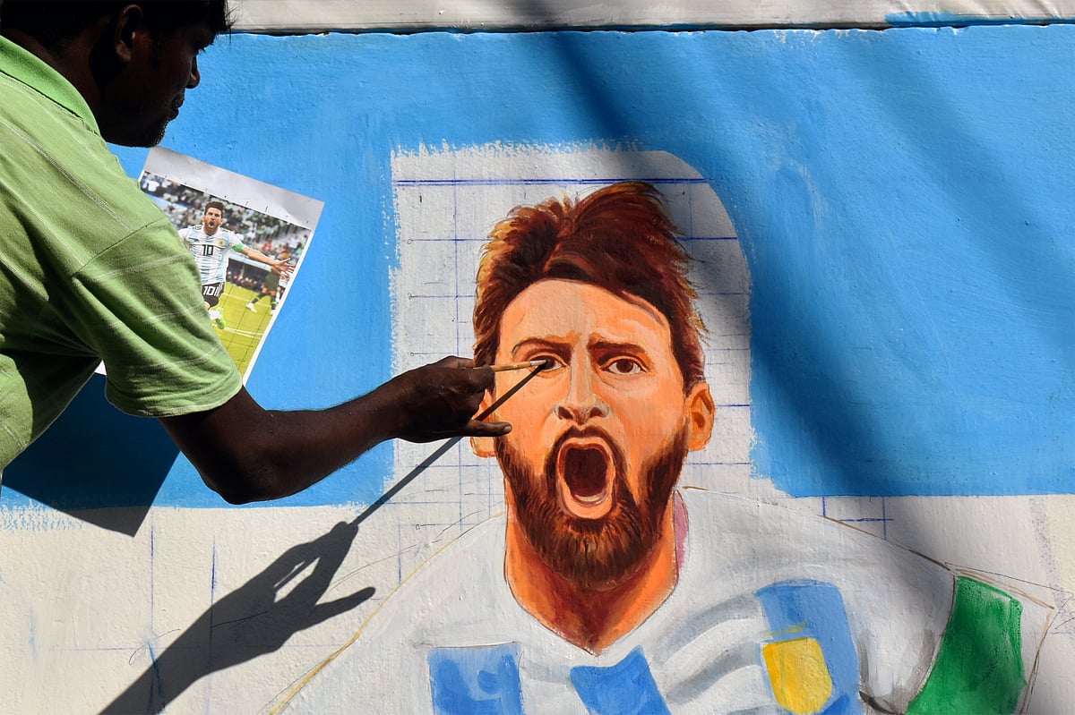 An artist paints a mural of Lionel Messi ahead of the FIFA World Cup