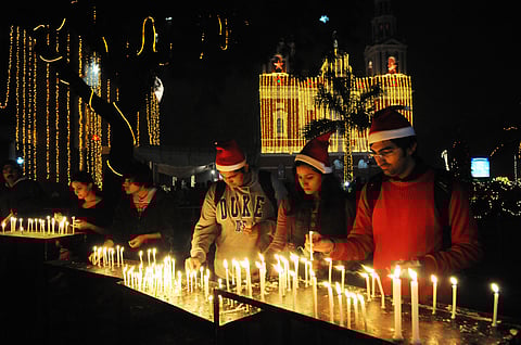 Devotees light candles and pray at the Sacred Heart Cathedral on the eve of Christmas in New Delhi