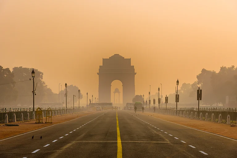 India Gate silhouetted against a smoggy winter morning in Delhi - Shutterstock