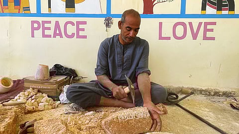Ramadan Komsan is hammering a large calcite chunk