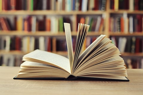 An open book among shelves in a quiet reading space
