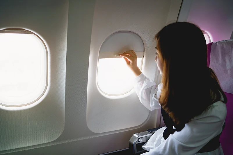 A passenger looks out of an aircraft window during a flight