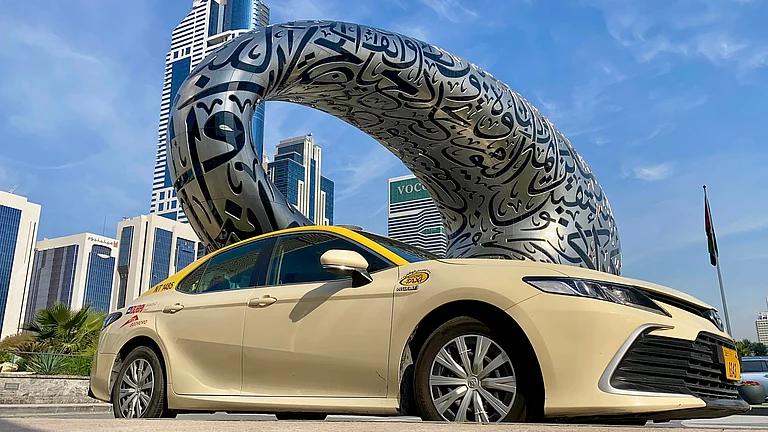 A taxi in Dubai parked near the Museum of the Future in Jumeirah - Shutterstock