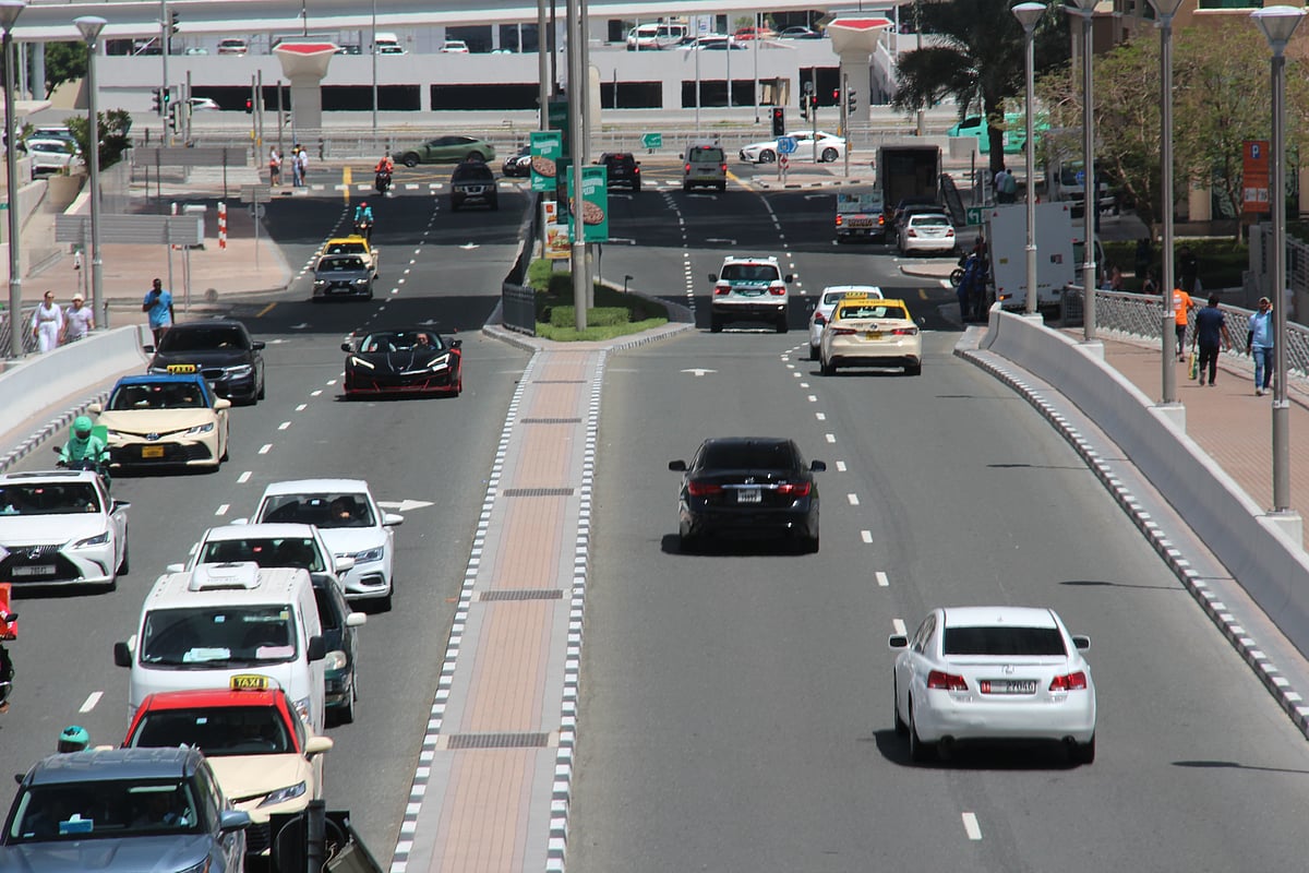 Traffic moves through Dubai’s palm-lined city roads