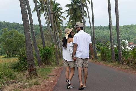 A couple strolls down Goa’s palm-lined Parra road