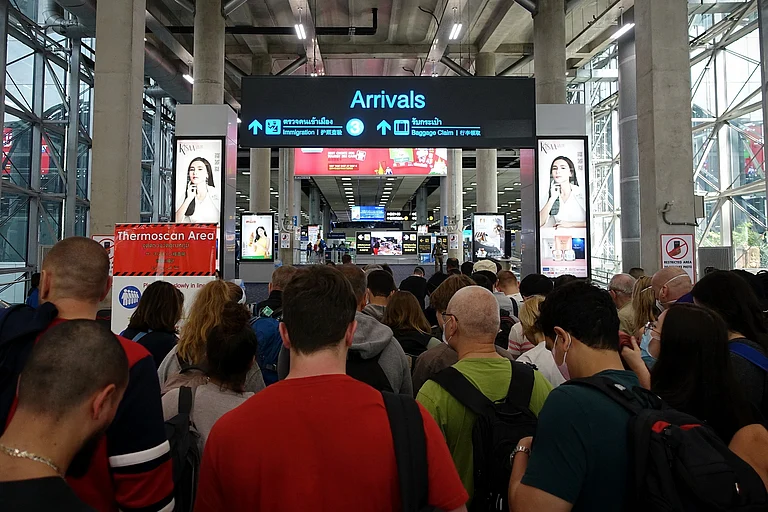 Travellers queue at passport control in Bangkok - Shutterstock