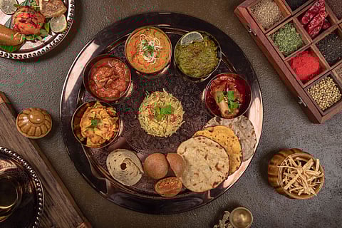 Clock wise from bottom: Keema batti, Papad, Rabodi ki sabji, Anjeer mutton, Murgh ka mokul, Dal methi machi, 31 mirch ka maans, Gehun roti, Missi roti and Bejad roti