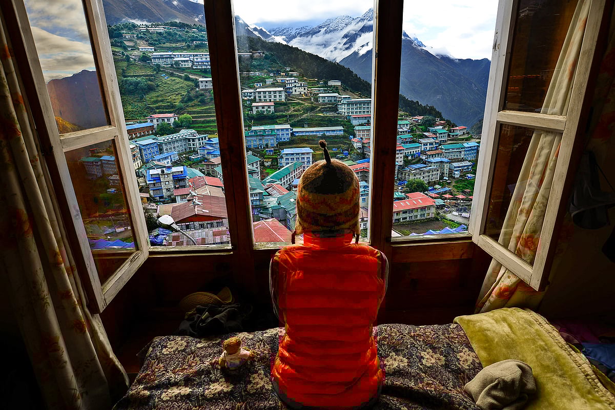 Trekker resting with a view of Namche village