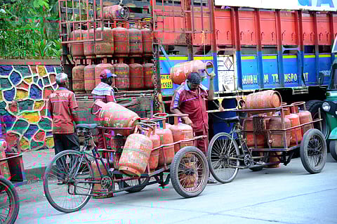 Workers transport home cooking LPG cylinders for delivery to customers in Mumbai