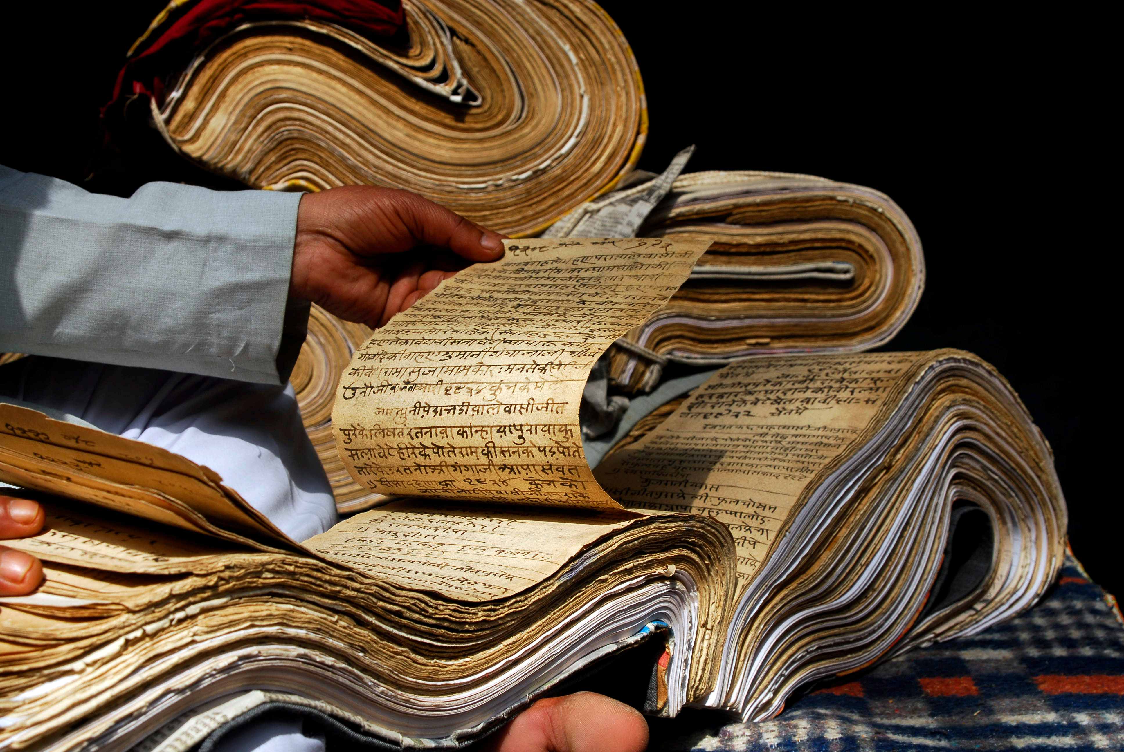 Shutterstock : A person examines ancient manuscripts