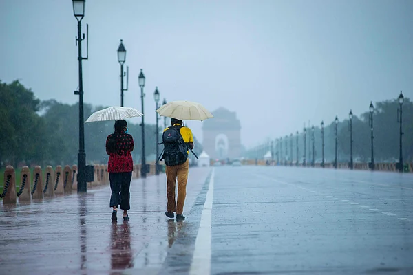 Shutterstock : Couple walking on a rain-soaked road near India Gate