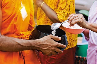 Shutterstock : Buddhist monks receiving alms during morning rounds