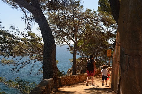 Mother and child walking on the Cami de Ronda Trail near Callela and Llafranc along the Mediterranean Sea