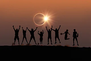 Shutterstock : Friends captured in silhouette during a solar eclipse