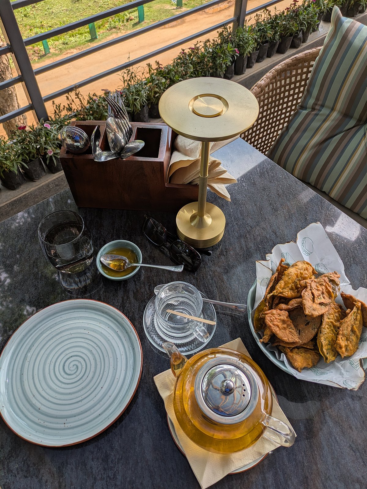 A plate of tea leaf pakoras alongside a cup of strong Assam tea.