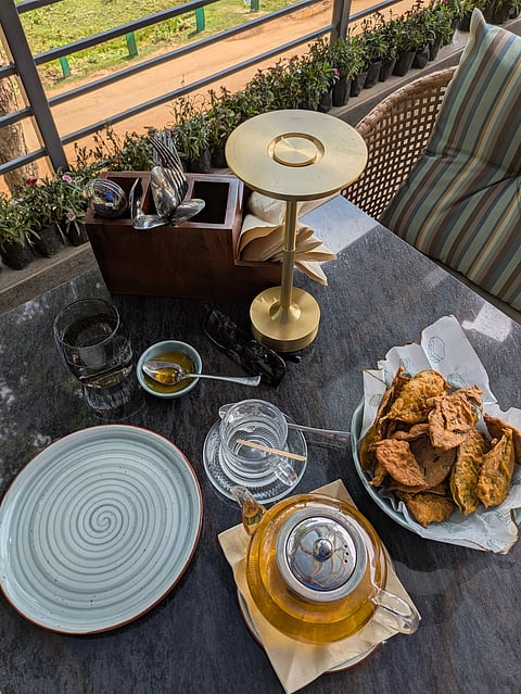 A plate of tea leaf pakoras alongside a cup of strong Assam tea.