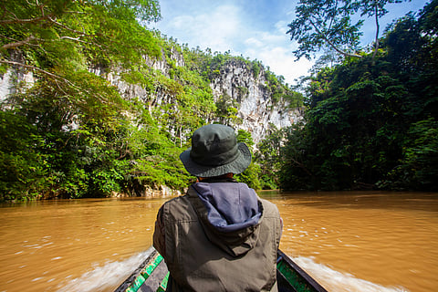 Boat journey through limestone cliffs in Borneo’s Batu Aji Karst