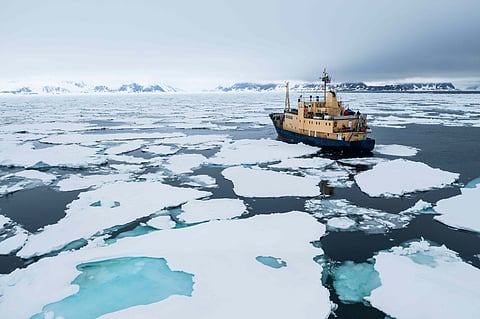 Expedition vessel navigating through sea ice in Svalbard
