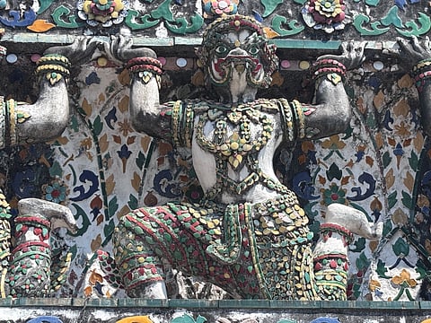 Guardian warrior on the central prang of Wat Arun in Bangkok, Thailand
