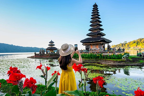 Shutterstock : A tourist taking in the serene views of Ulun Danu Beratan Temple in Bali