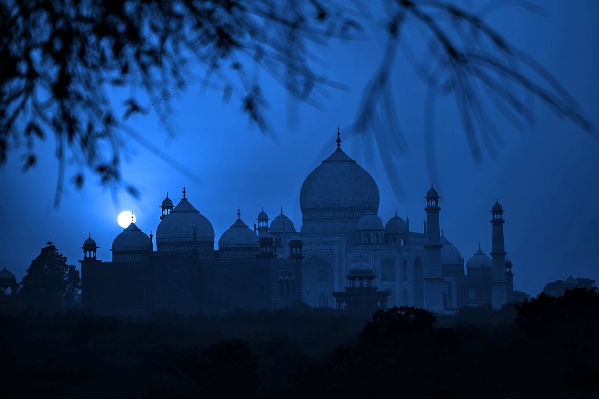 The Taj Mahal glows softly under the light of a full moon in Agra