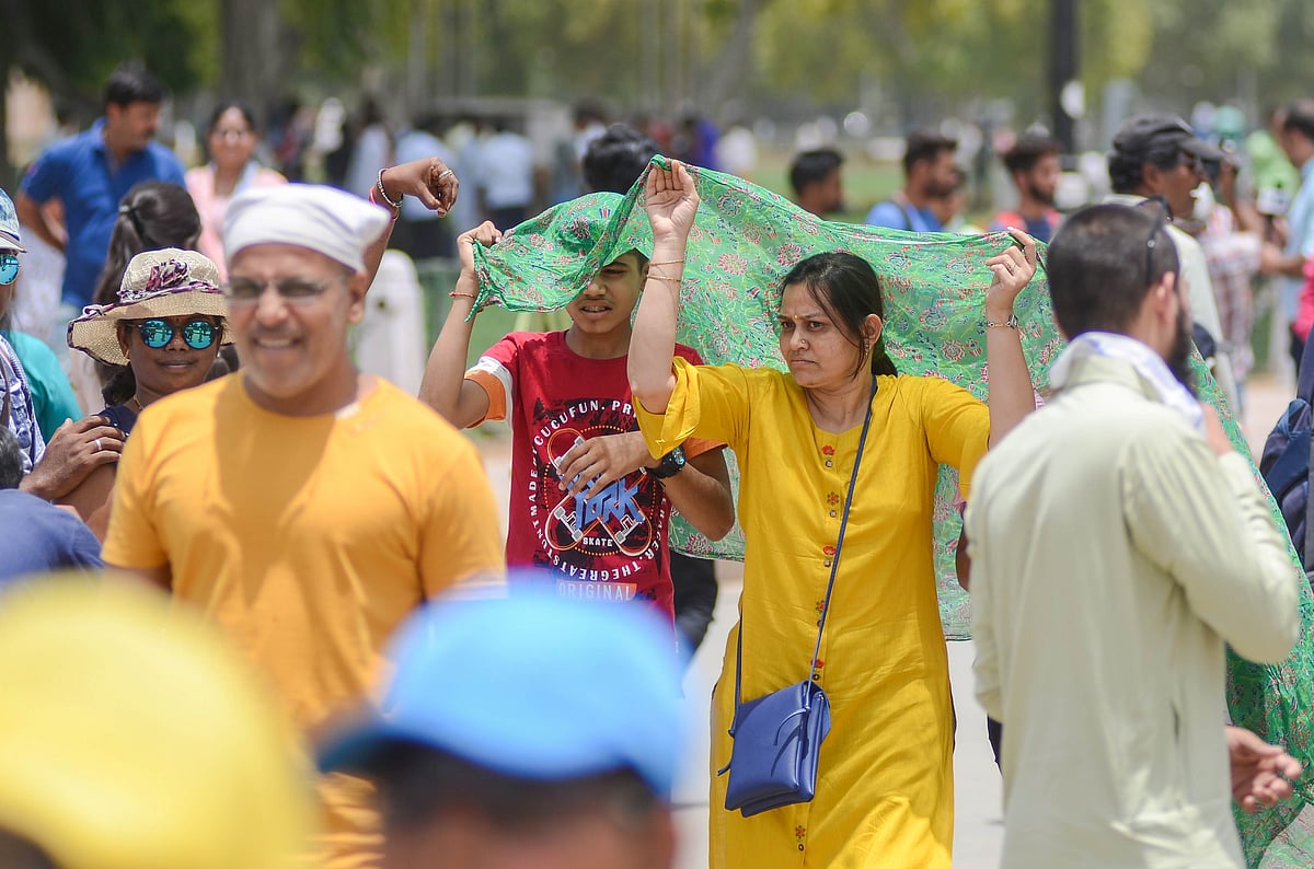 Tourists shield themselves from extreme heat as temperatures soar in New Delhi