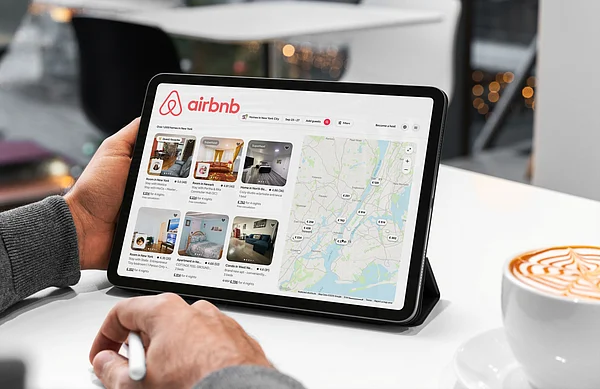 Shutterstock : A traveller browses Airbnb listings while planning a trip