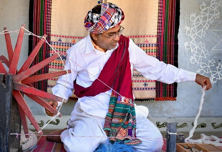 The Vankar family of Bhujodi represents a multi-generational legacy of master weavers in India's famous craft village of Bhujodi, located just 8 km from Bhuj in Kutch, Gujarat. In frame: Chaman Siju, National Award-winning Bhujodi weaver (2001) and uncle of Vankar Chetan, preparing yarn using a traditional spinning wheel. - Vankar Chetan