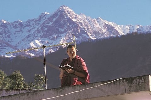 McLeod Ganj/Himachal Pradesh: A Tibetan monk in McLeod Ganj framed against the mountains, embodying the town’s enduring connection with Tibetan exile, spirituality, learning, and monastic life