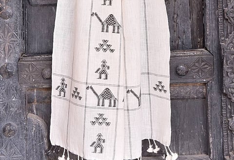 The cloth they produce — shawls, sarees, blankets — is instantly recognisable: bold geometric patterns raised off a plain-woven surface, each motif built thread by thread from within the fabric itself.