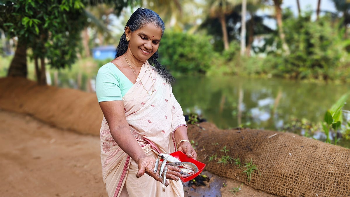 A local woman shows a fresh catch from the backwaters of Kumarakom