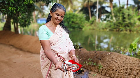 A local woman shows a fresh catch from the backwaters of Kumarakom