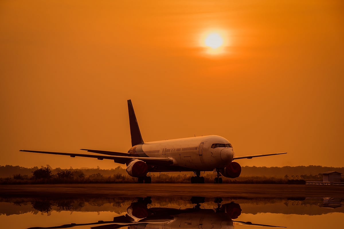 Shutterstock : A airplane lands on an offshore platform at sunset