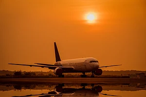 Shutterstock : A airplane lands on an offshore platform at sunset